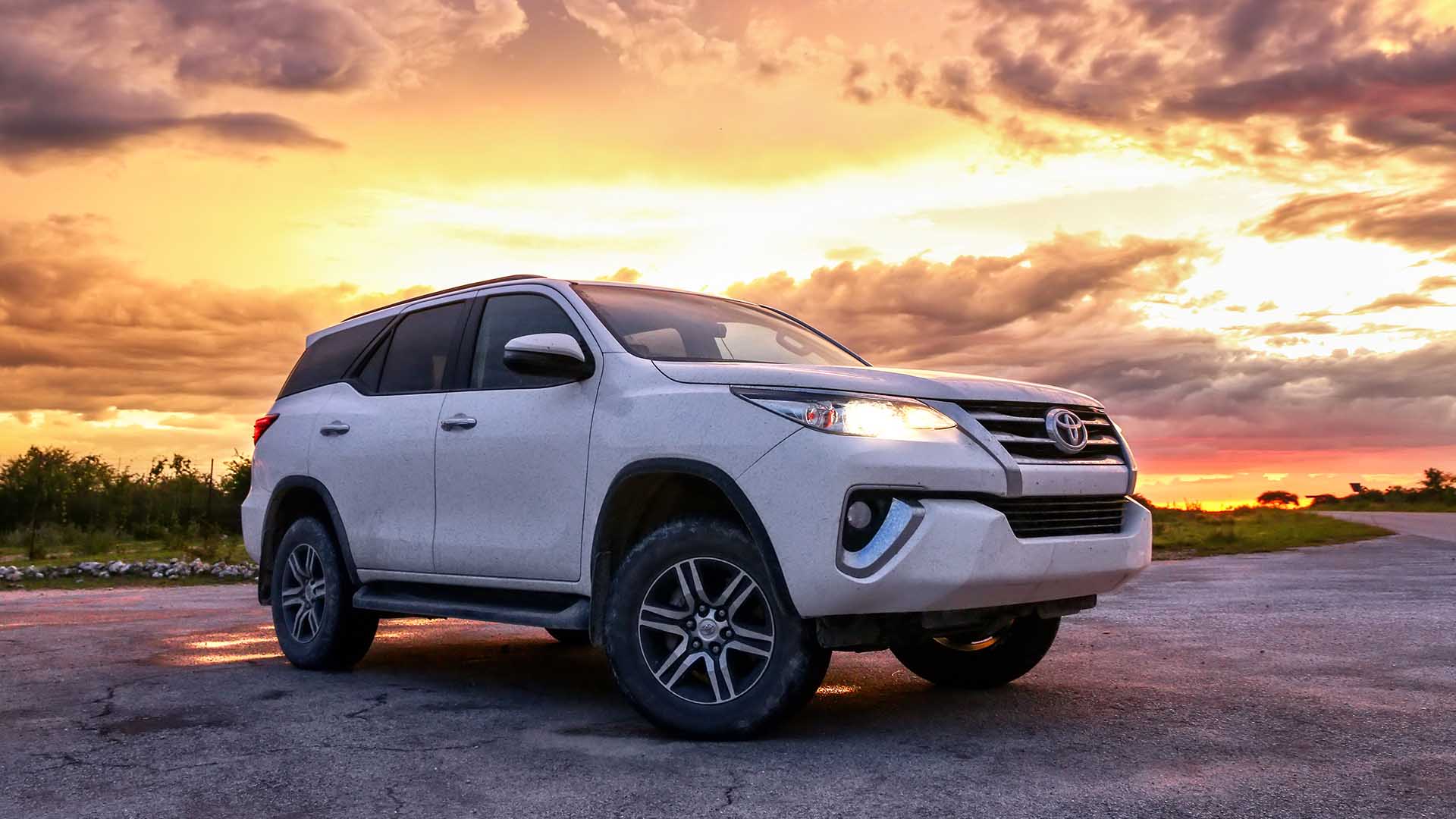 Fortuner car parked at sunset with red sky - Premium vehicle for comfortable outstation and event travel.